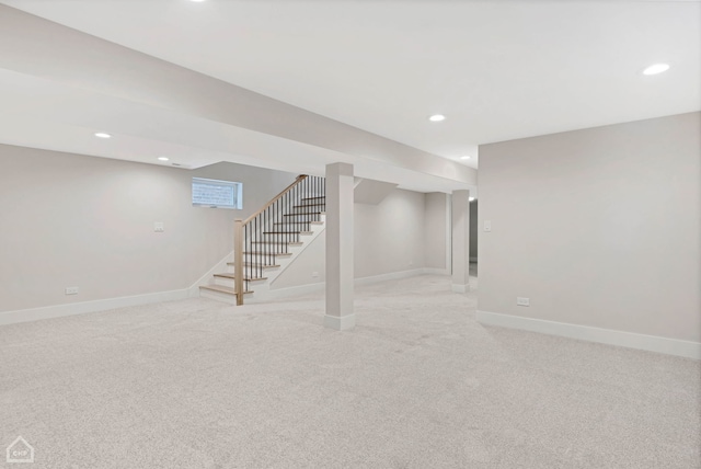 finished basement with recessed lighting, light colored carpet, stairway, and baseboards