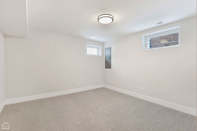 below grade area with carpet, electric panel, visible vents, and baseboards