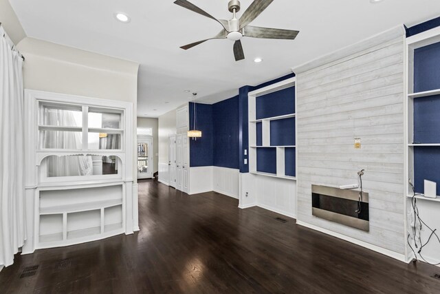 unfurnished living room featuring built in shelves, recessed lighting, dark wood-type flooring, a fireplace, and a ceiling fan