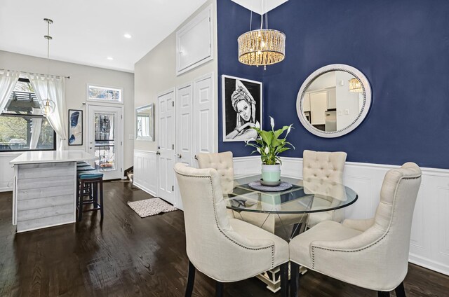 dining space featuring a wainscoted wall, a notable chandelier, recessed lighting, dark wood-type flooring, and an accent wall