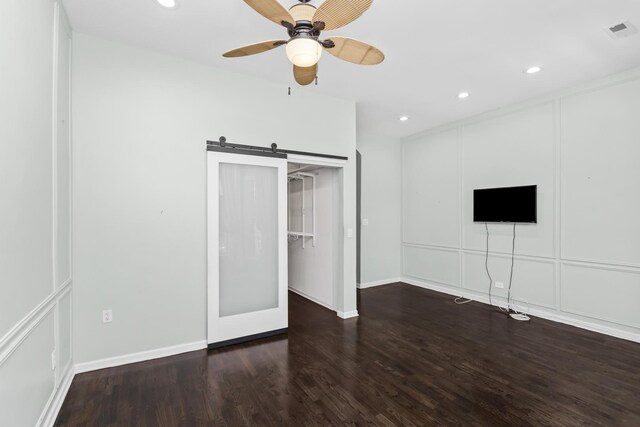 unfurnished bedroom featuring a barn door, visible vents, dark wood finished floors, baseboards, and recessed lighting