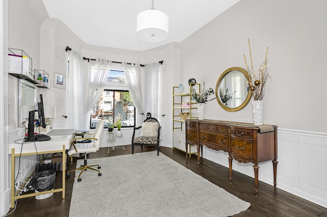 office space with a decorative wall, dark wood-type flooring, and wainscoting