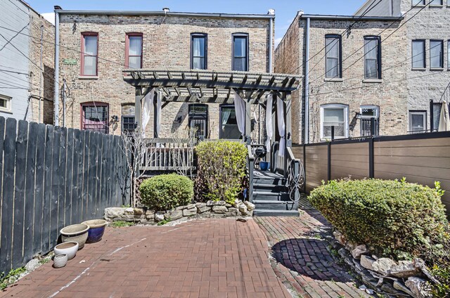 exterior space featuring a patio, fence, a pergola, and brick siding