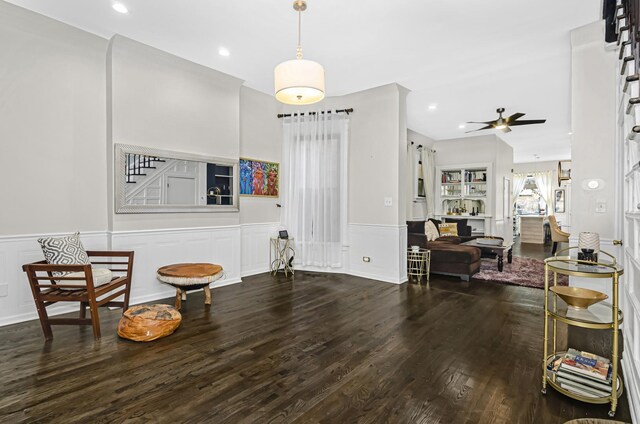 living area with ceiling fan, wainscoting, and wood finished floors