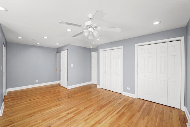 unfurnished bedroom with baseboards, a ceiling fan, light wood-type flooring, two closets, and recessed lighting