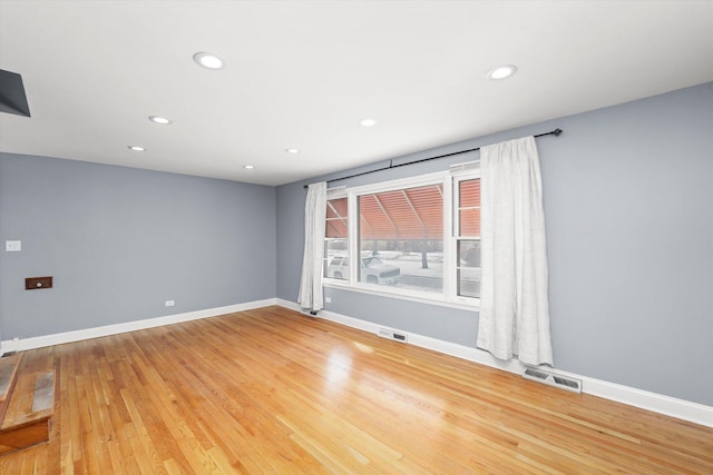 spare room with recessed lighting, wood finished floors, visible vents, and baseboards