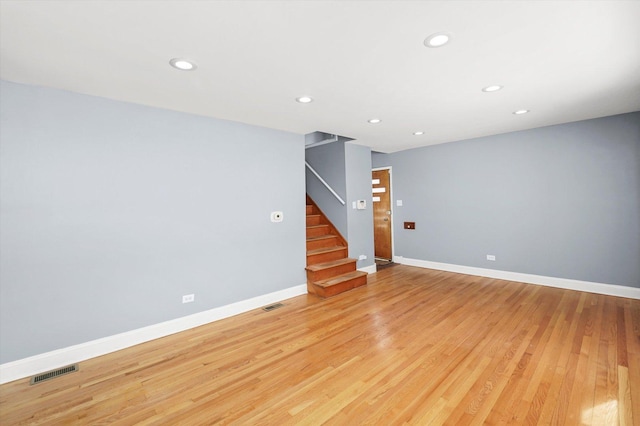 spare room with light wood-style flooring, visible vents, and baseboards