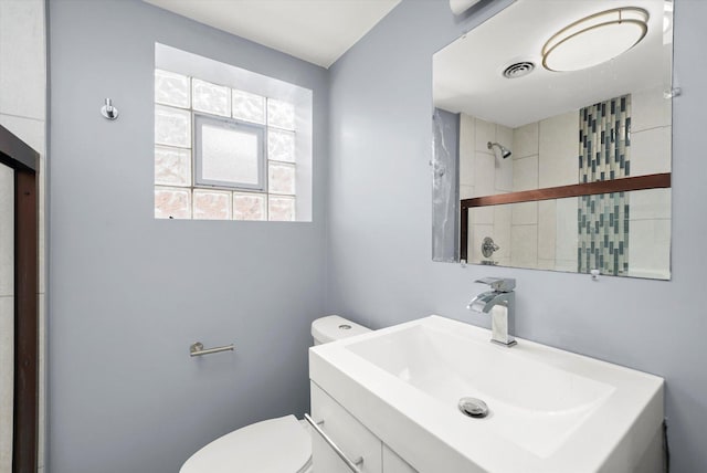 bathroom featuring toilet, visible vents, walk in shower, and vanity