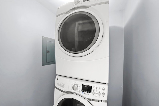 laundry room with stacked washer and dryer, electric panel, and laundry area