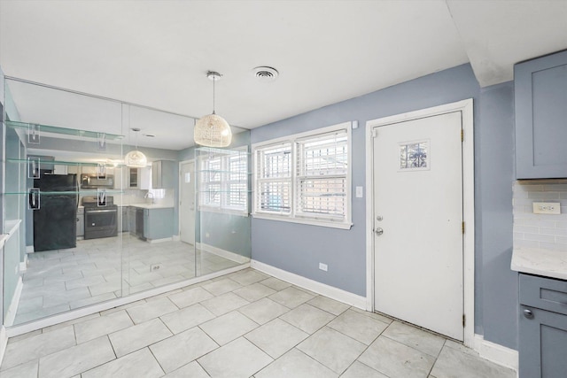 unfurnished dining area with light tile patterned floors, visible vents, and baseboards