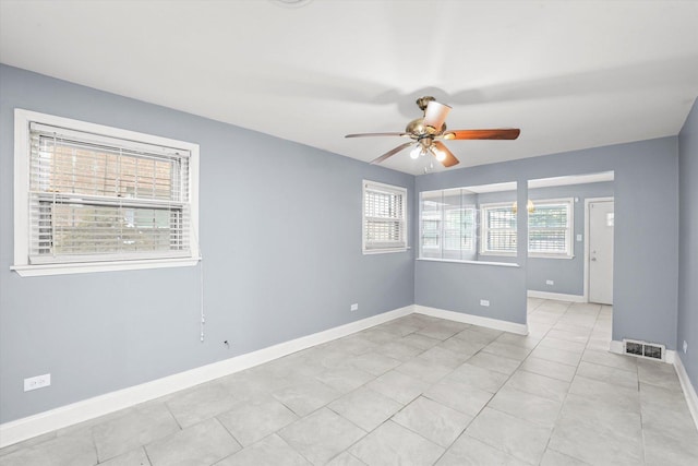 spare room featuring ceiling fan, light tile patterned floors, visible vents, and baseboards