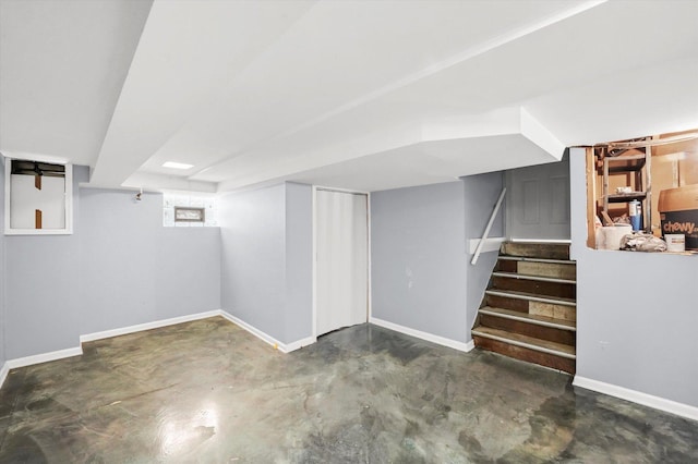 basement featuring stairway and baseboards