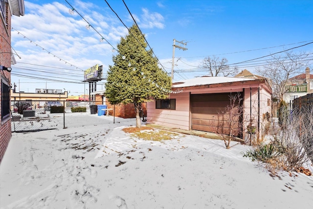 view of front of property with a detached garage, fence, and an outdoor structure