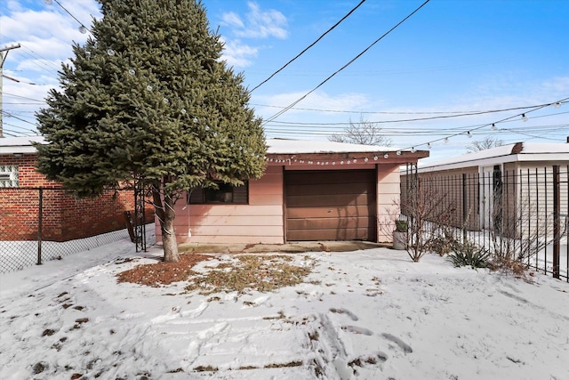 exterior space with a detached garage and fence