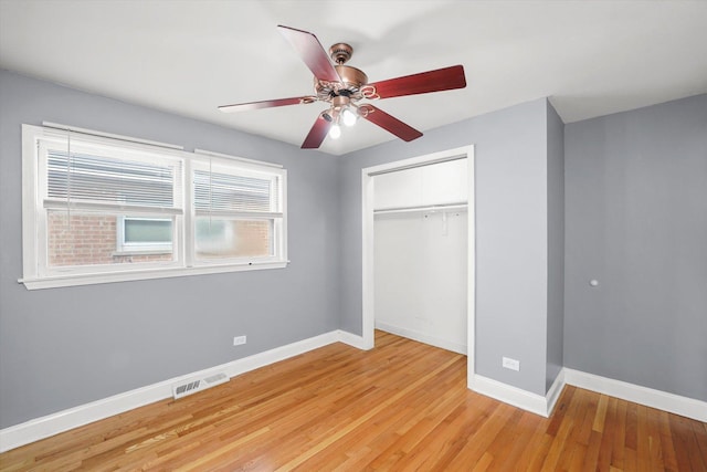 unfurnished bedroom with visible vents, a closet, light wood-style flooring, and baseboards