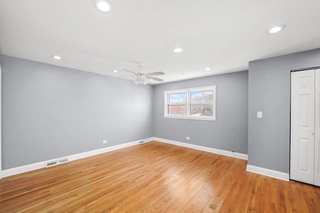 empty room with recessed lighting, visible vents, light wood-style flooring, a ceiling fan, and baseboards