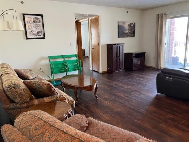 living area with dark wood-style flooring and baseboards