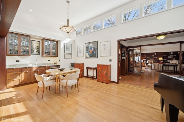 dining room featuring light wood-style flooring and a high ceiling