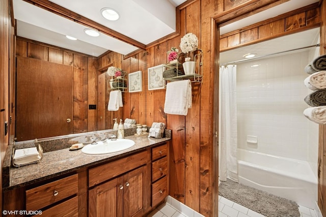 bathroom with wood walls, shower / bath combo, and vanity