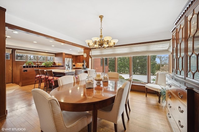 dining area with light wood-type flooring, an inviting chandelier, and recessed lighting