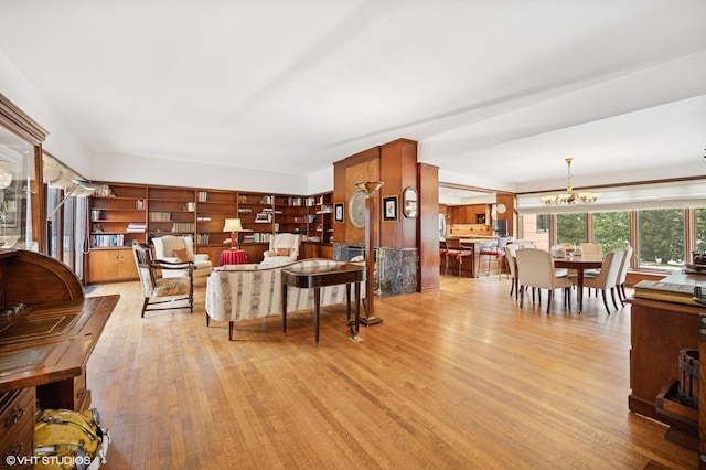 living area with light wood-style flooring and a notable chandelier