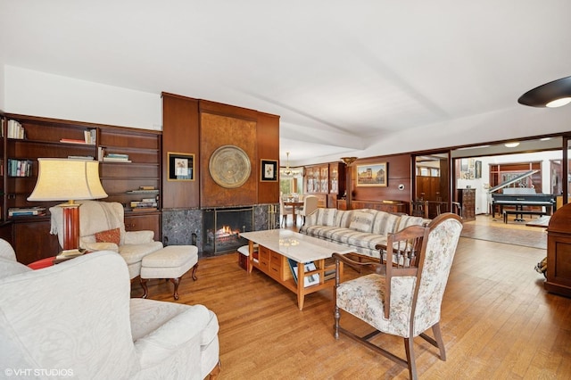 living room with lofted ceiling, a fireplace, and light wood finished floors