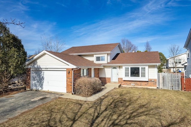 traditional-style house with a garage, brick siding, fence, driveway, and a front yard