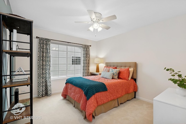 bedroom featuring a ceiling fan, light colored carpet, and baseboards