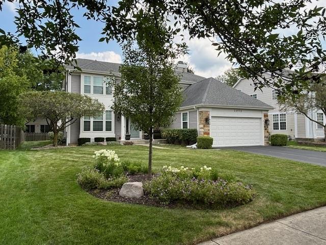 view of front of house featuring a front yard, driveway, and an attached garage