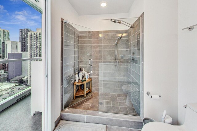 bathroom with toilet, a shower stall, and a view of city