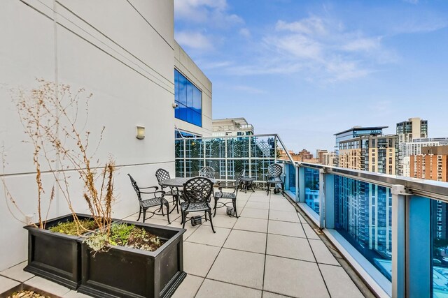 balcony featuring a view of city and outdoor dining area