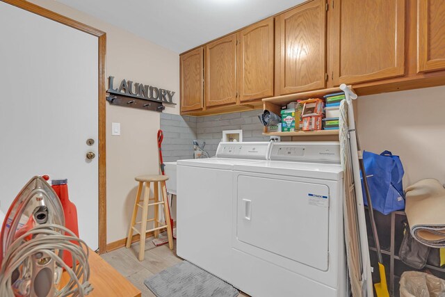 laundry room featuring baseboards, cabinet space, and washer and dryer