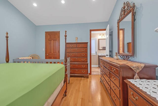 bedroom with recessed lighting, connected bathroom, and light wood finished floors