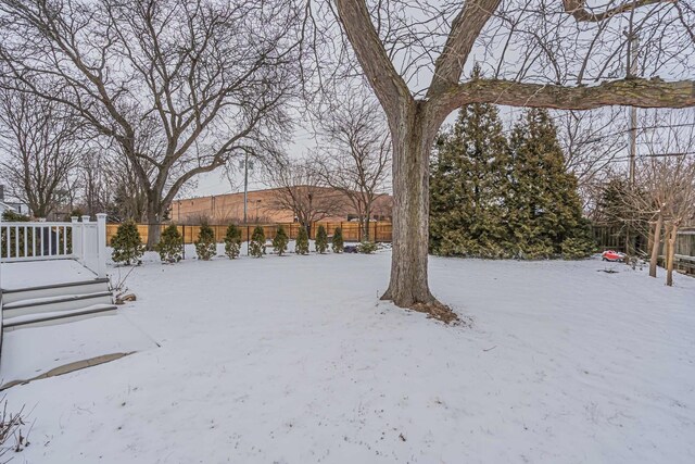 yard covered in snow with fence