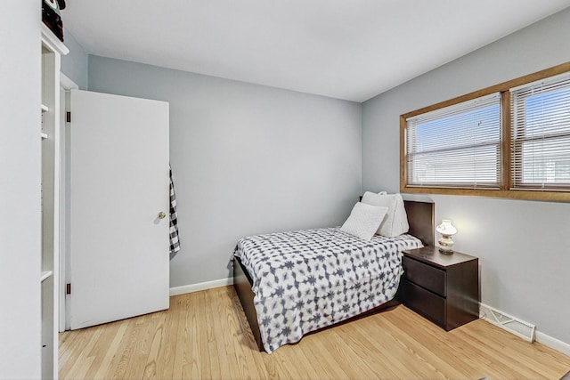 bedroom with visible vents, baseboards, and wood finished floors