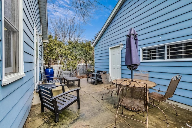 view of patio with outdoor dining space and fence