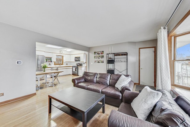 living room featuring baseboards and light wood finished floors