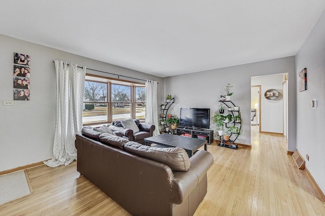 living area featuring light wood-type flooring and baseboards