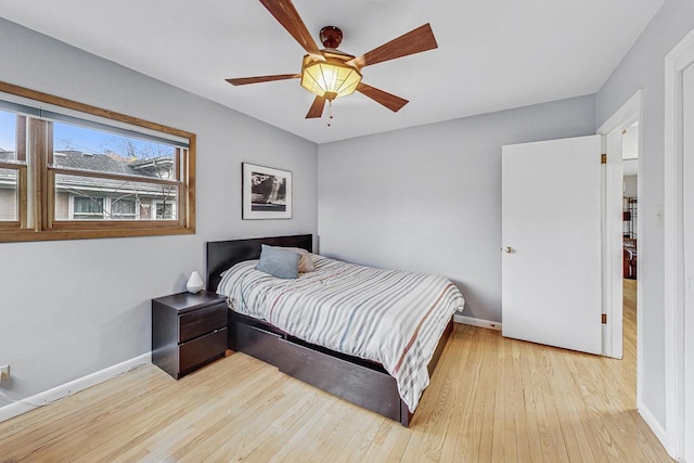 bedroom featuring ceiling fan, baseboards, and wood finished floors