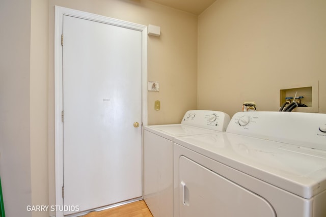 laundry room with light wood-style floors, laundry area, and washing machine and clothes dryer