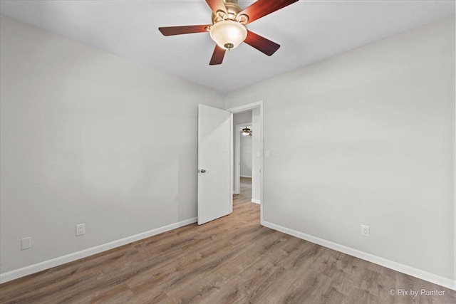 empty room featuring baseboards, a ceiling fan, and wood finished floors