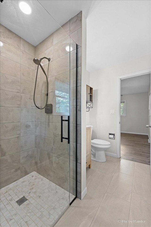 bathroom featuring baseboards, vanity, tile patterned floors, and a shower stall