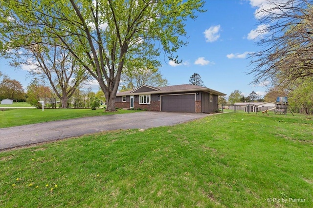 single story home with brick siding, a garage, a front lawn, and aphalt driveway