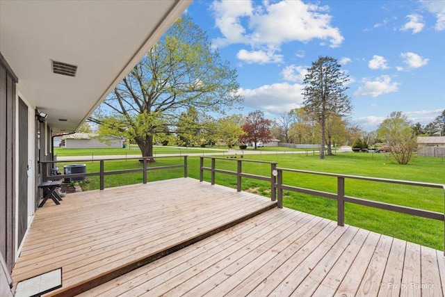 wooden deck featuring visible vents, central AC, and a yard