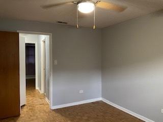 empty room featuring ceiling fan and baseboards