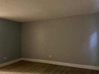 spare room with wood finished floors and baseboards