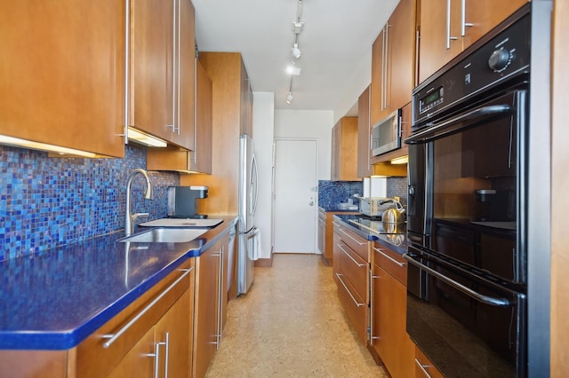 kitchen with stainless steel appliances, dark countertops, a sink, and brown cabinets