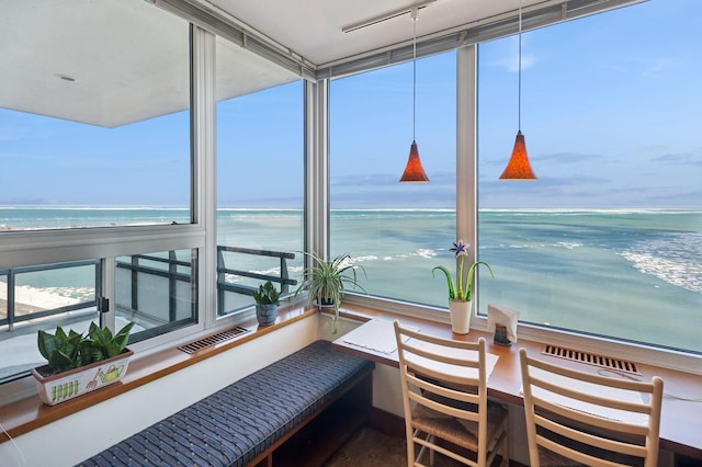 balcony featuring a view of the beach, a water view, and visible vents