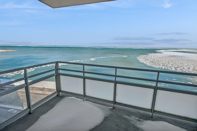 balcony featuring a view of the beach and a water view