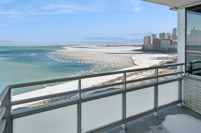 balcony with a water view and a view of the beach